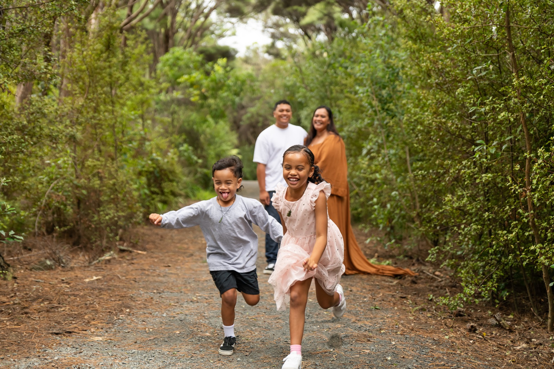 kids running toward the camera, while parents smile in the background