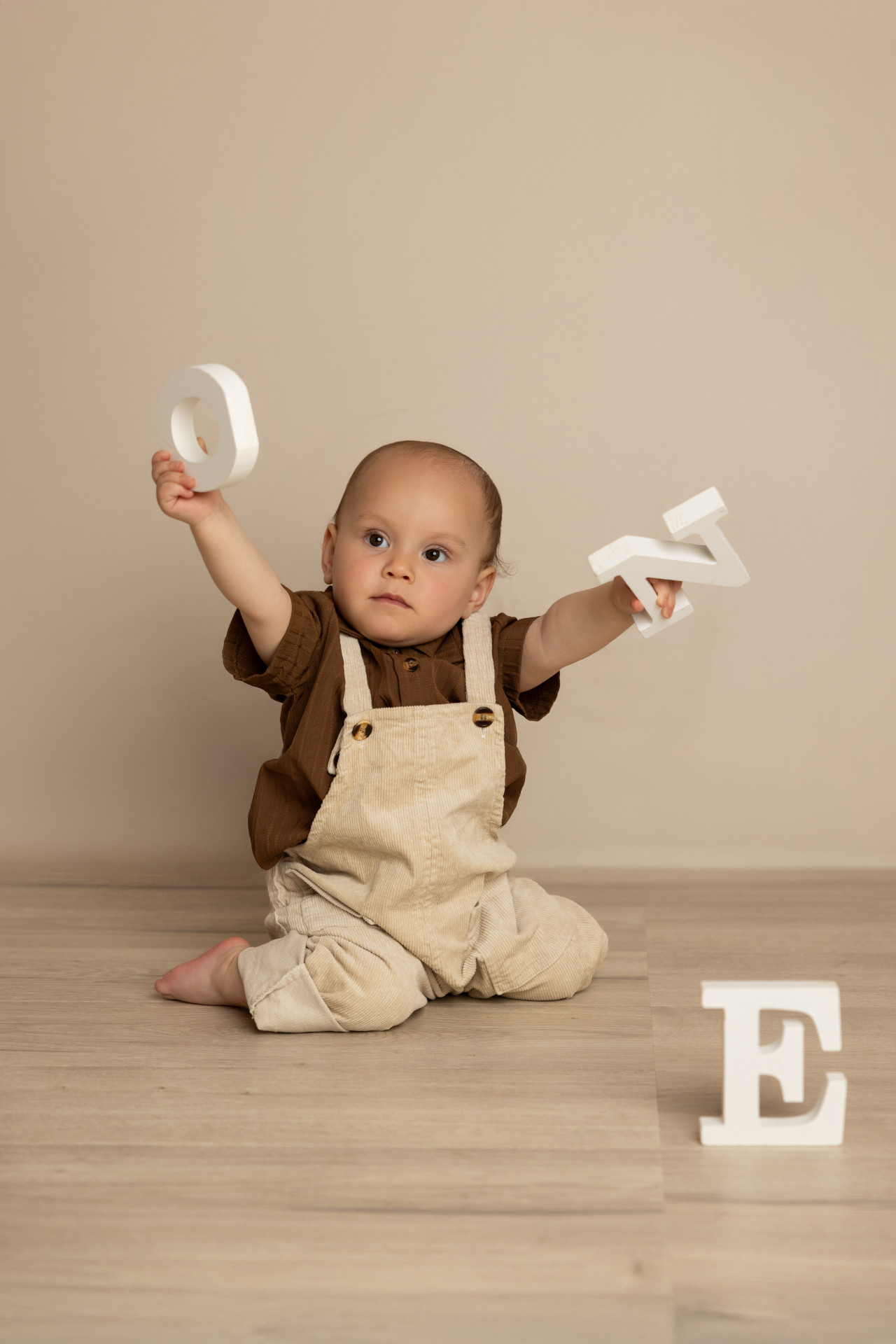 baby holding letters one