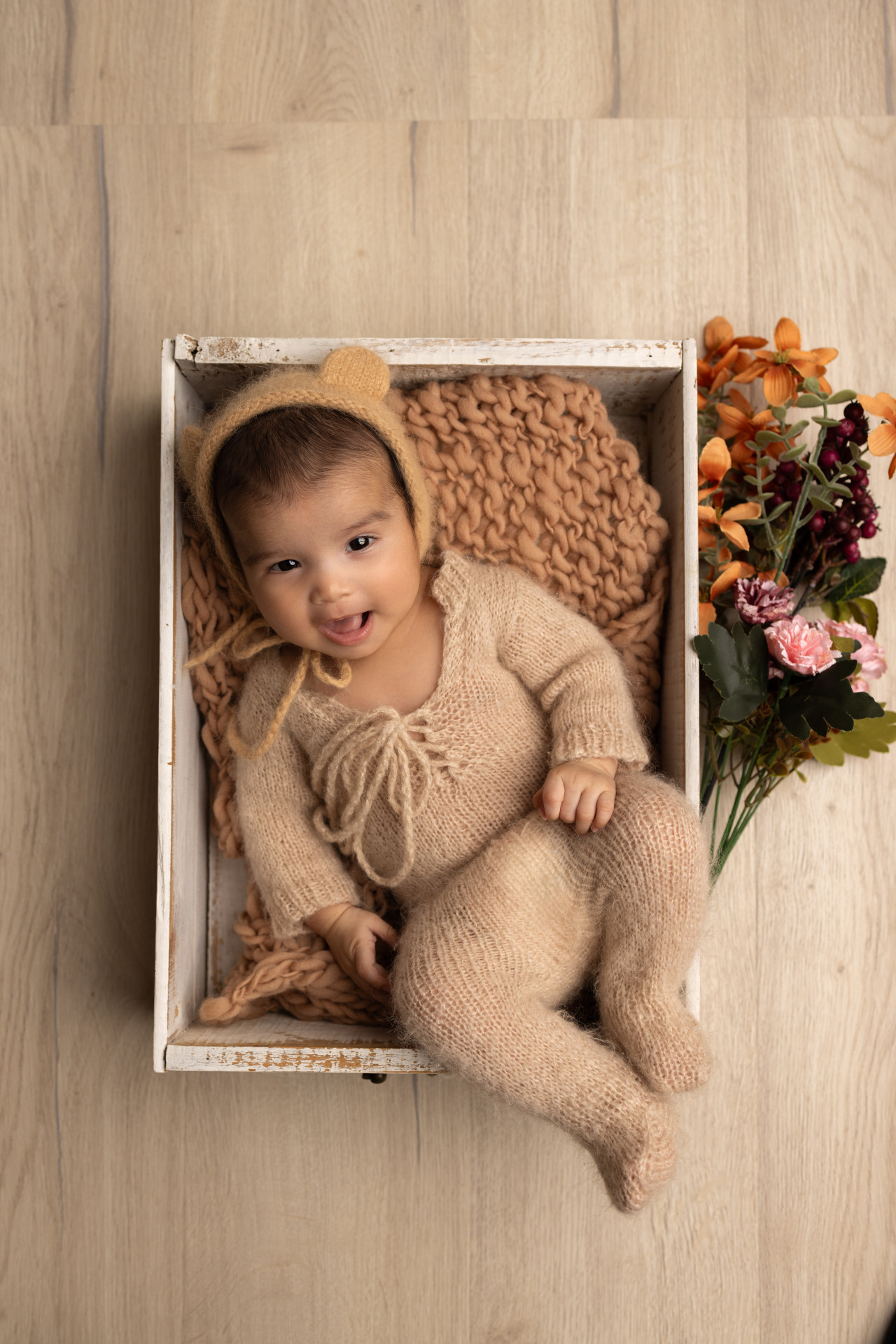 baby dressed in teddy outfit in the basket