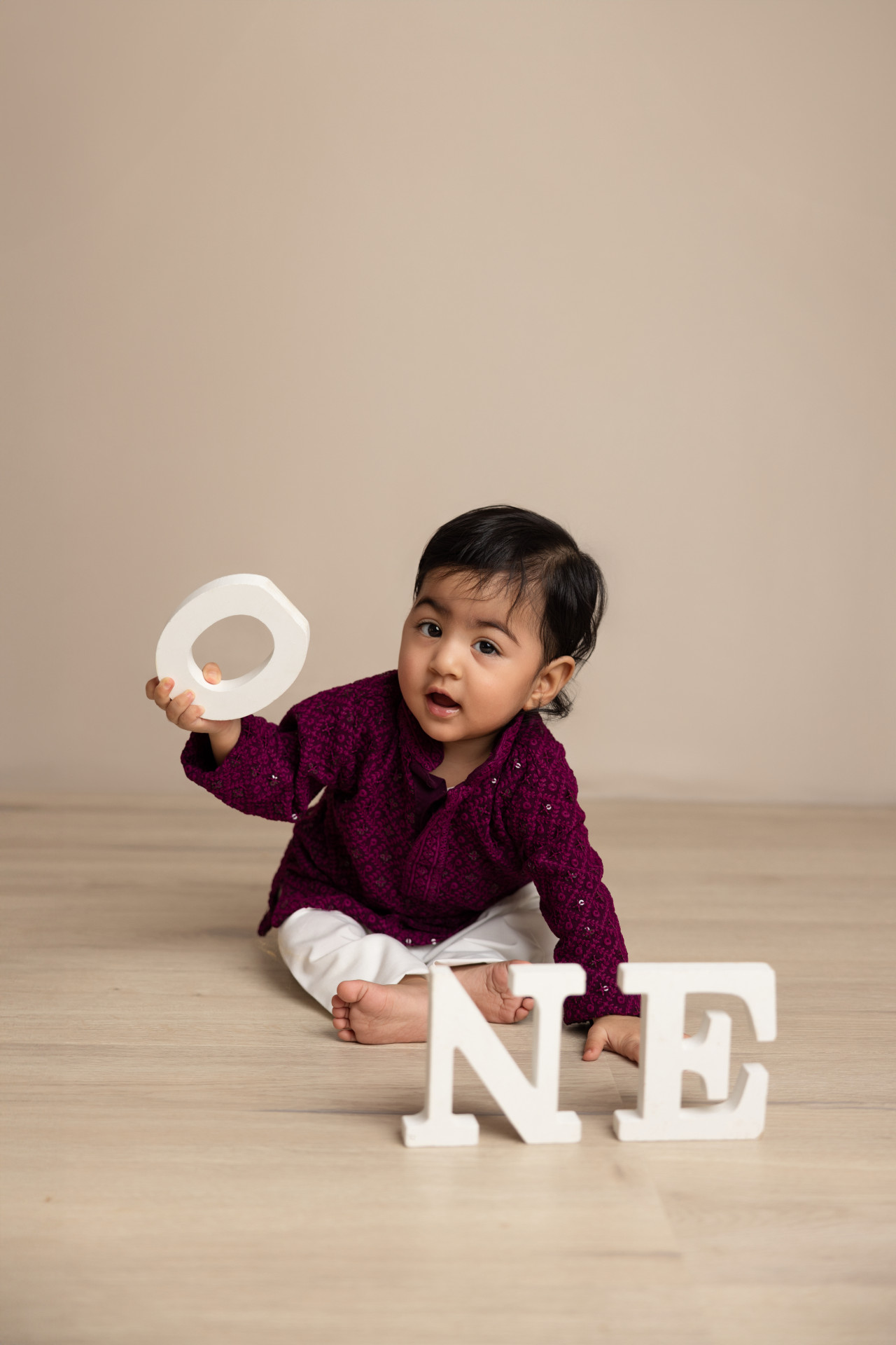 baby holding letters one