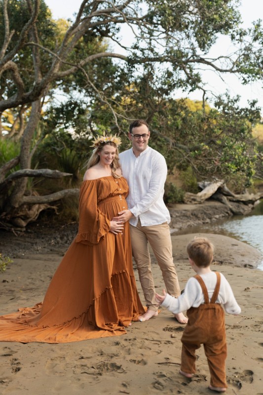 family having fun on the beach during their maternity session with elia making memories