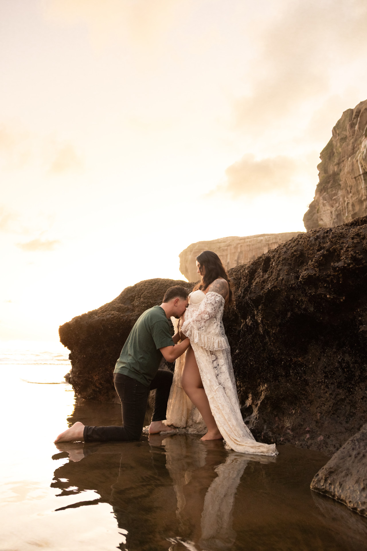 dad kissing pregnant belly at the cliffs