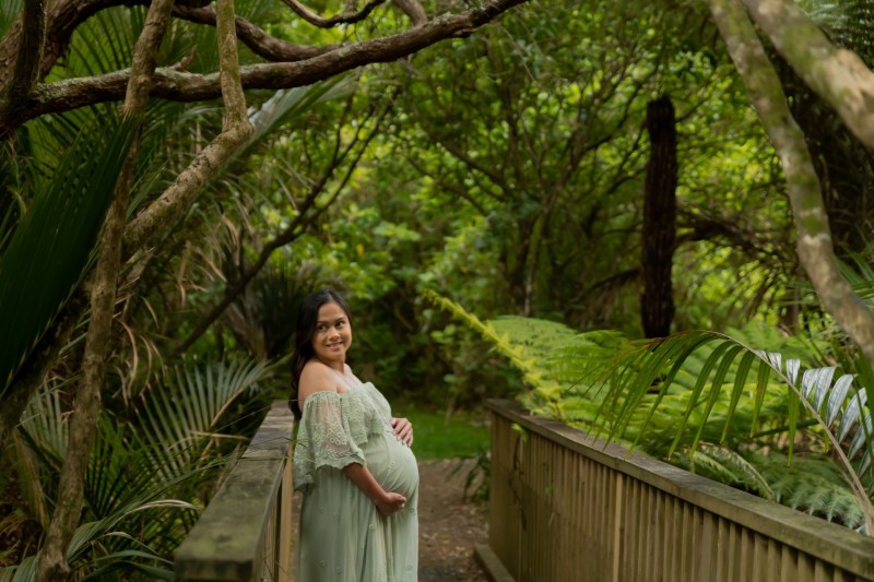 maternity photo in the forest with the green lace dress