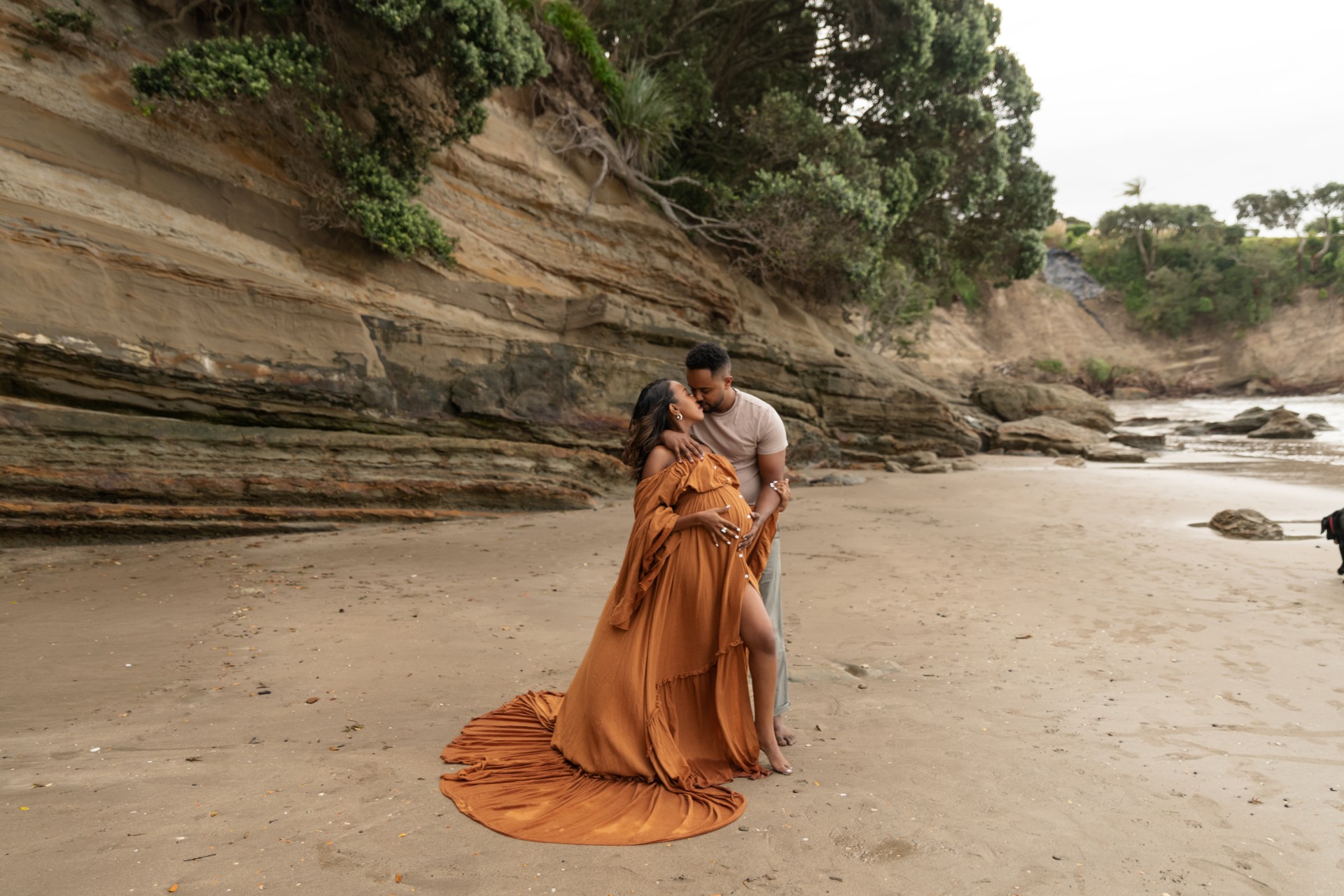 couple kissing during their maternity photosession on narrow neck