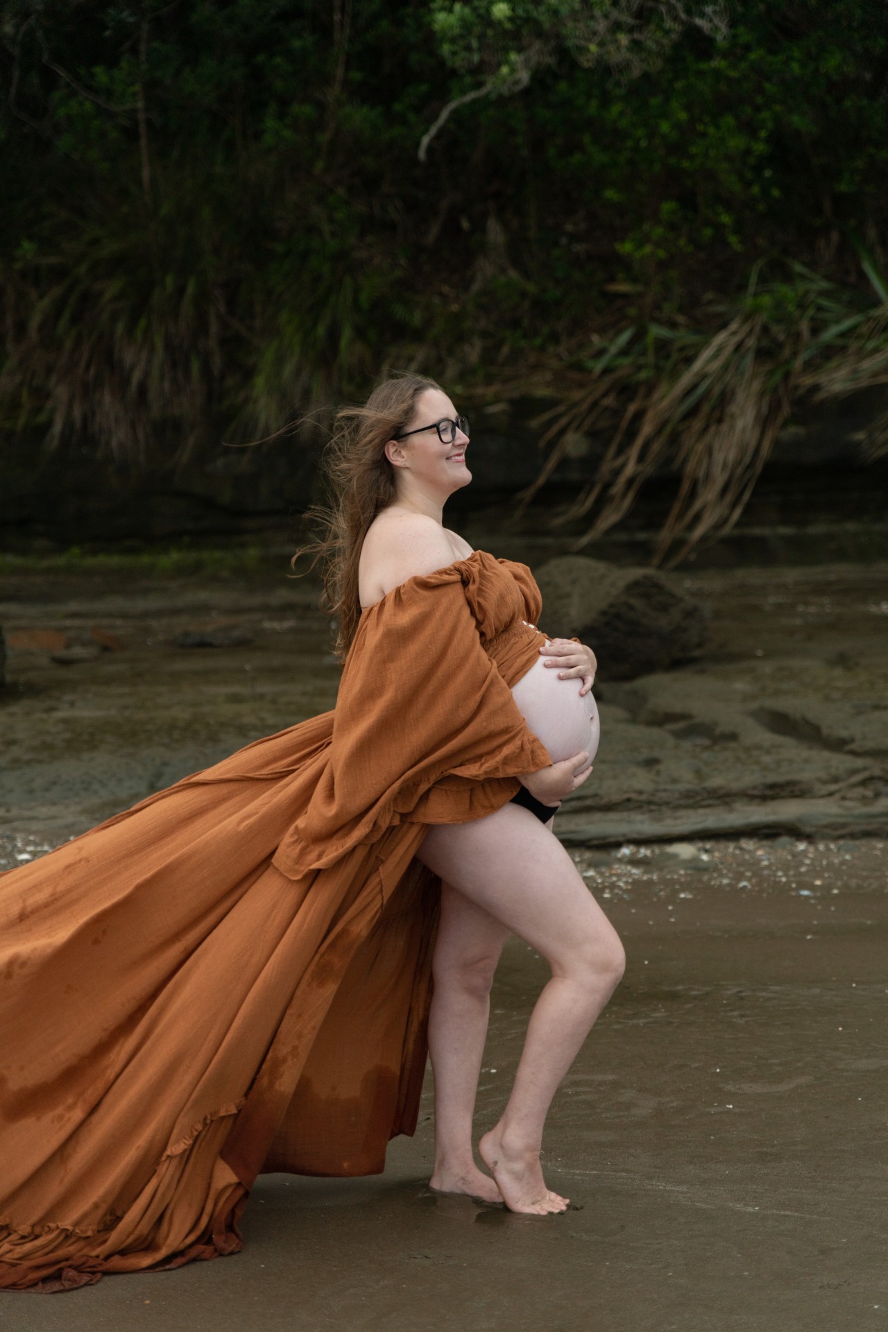 pregnant lady holding the baby bump in orange dress