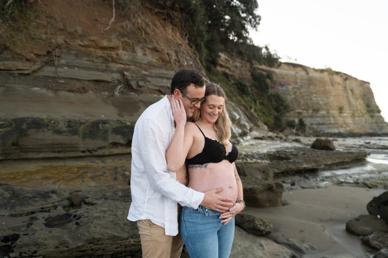 couple in the jeans and shirt touching pregnant baby belly