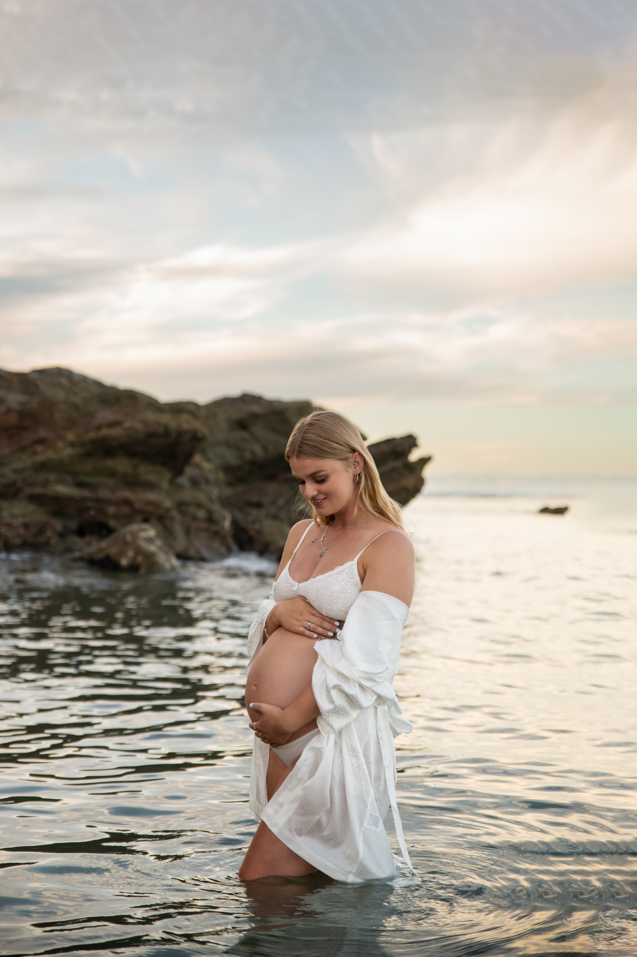 pregnant mum with the white robe standing in the deep water