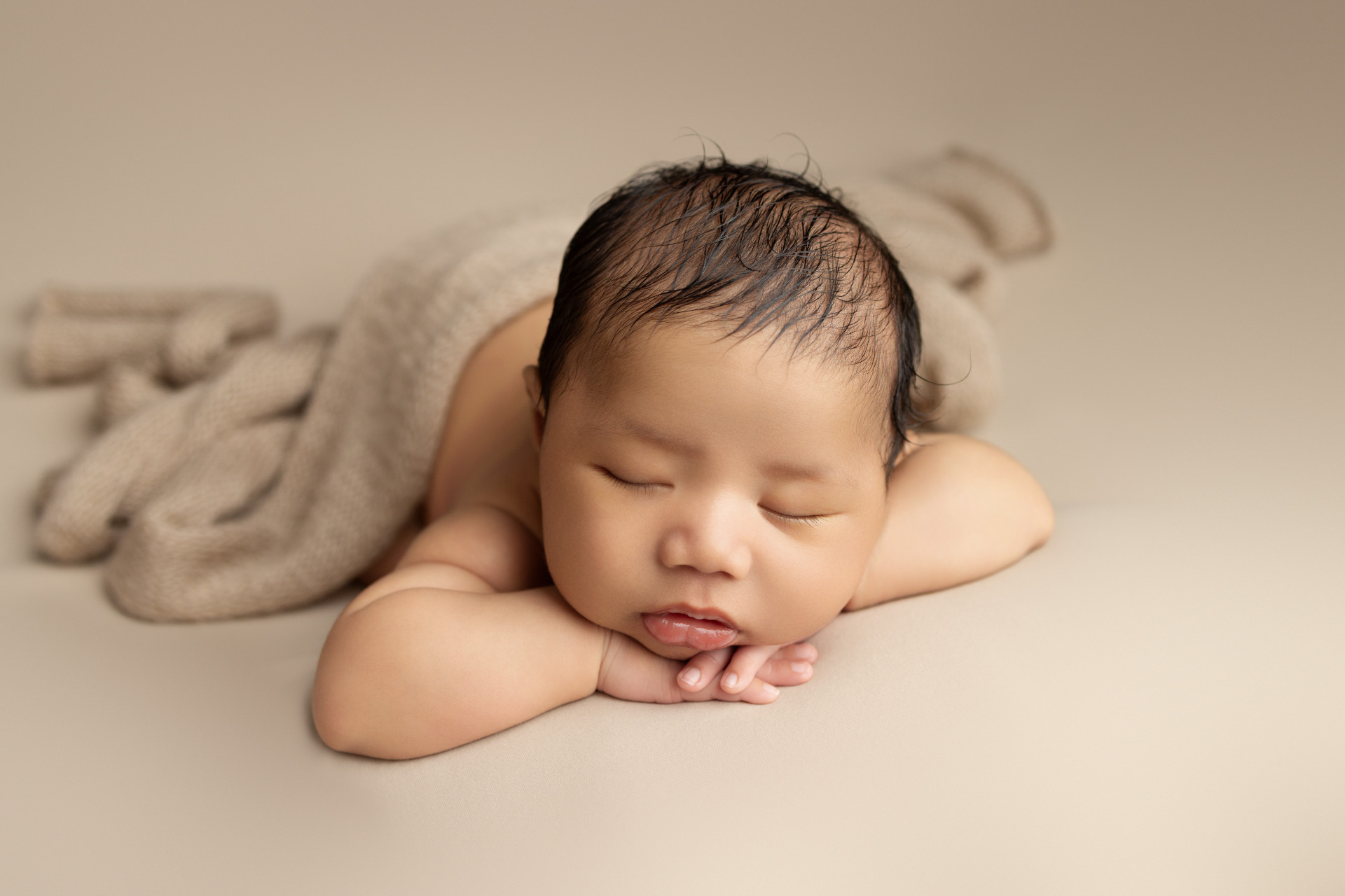 baby sleeping with chin on hands