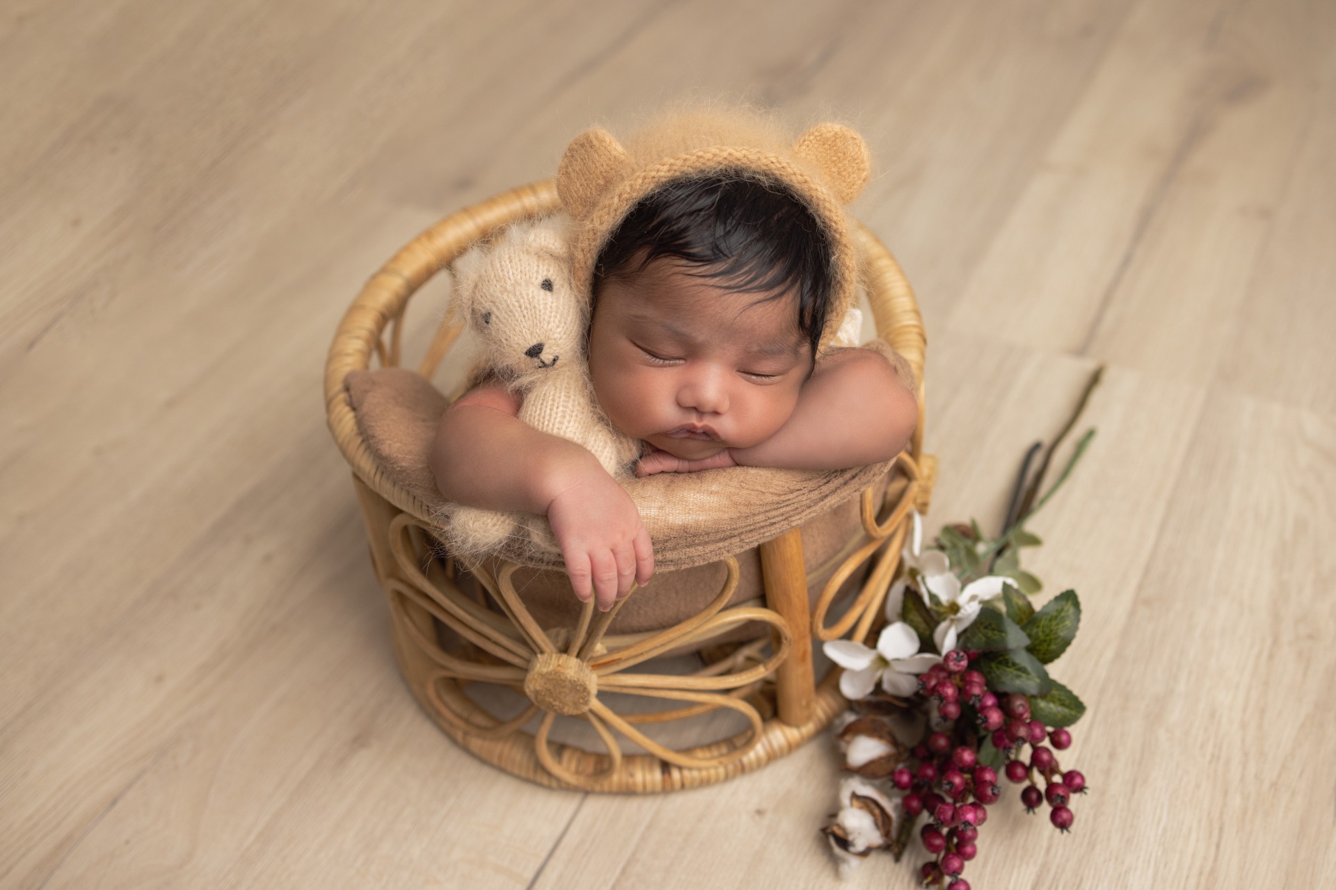 baby with teddy hat in floral basket