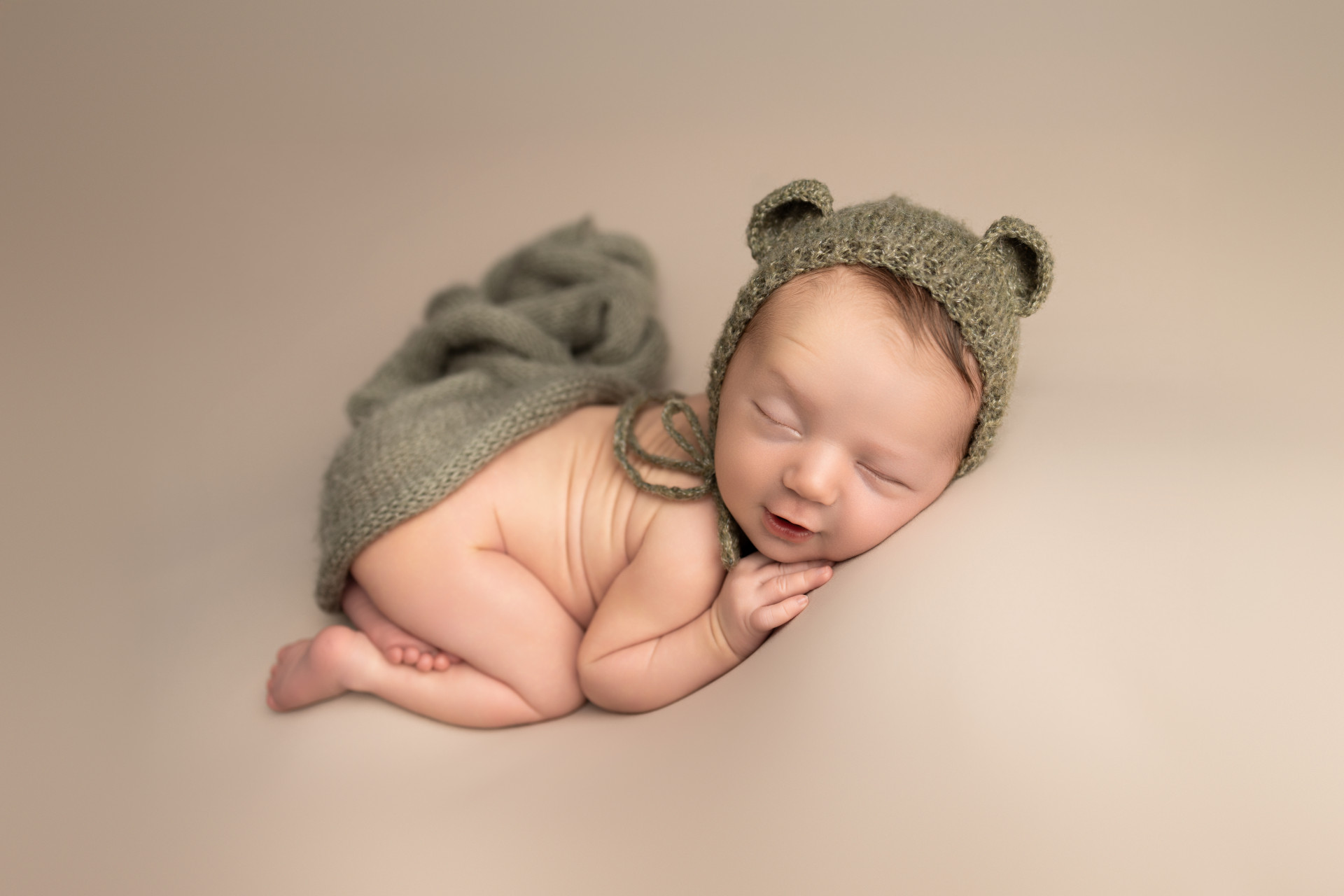 newborn wearing teddy bonnet