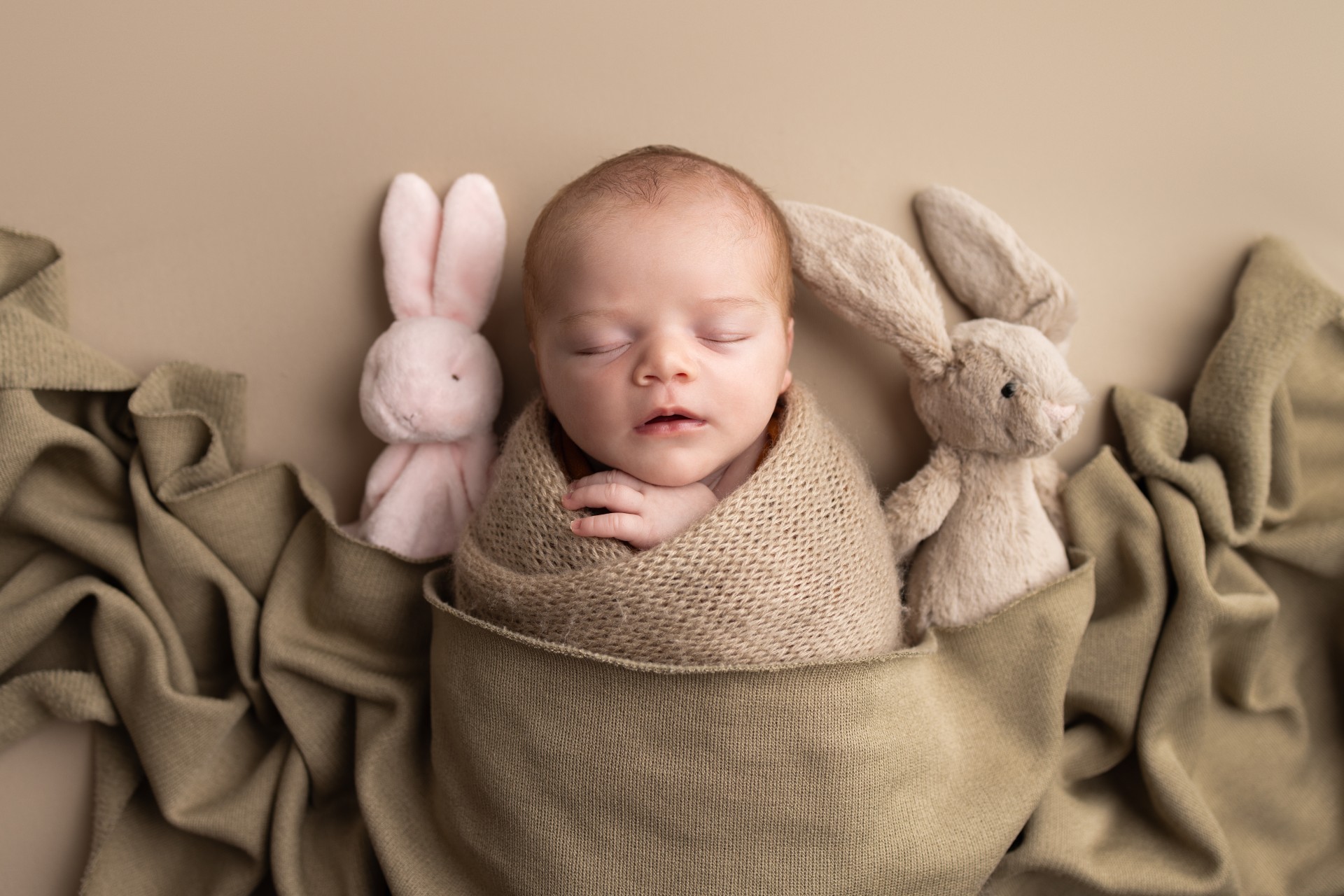 baby with rabbit cuddlies