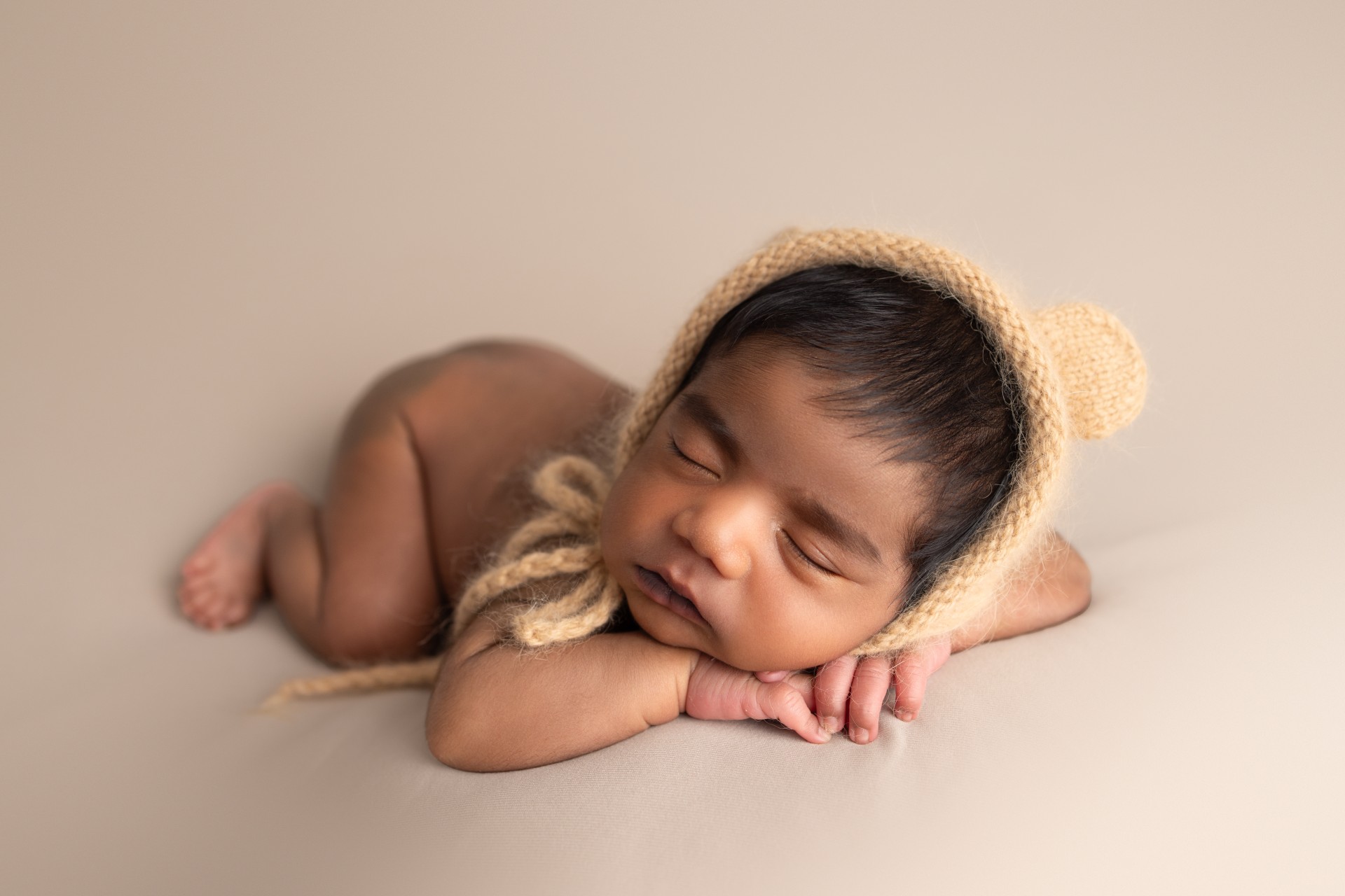 newborn wearing teddy hat