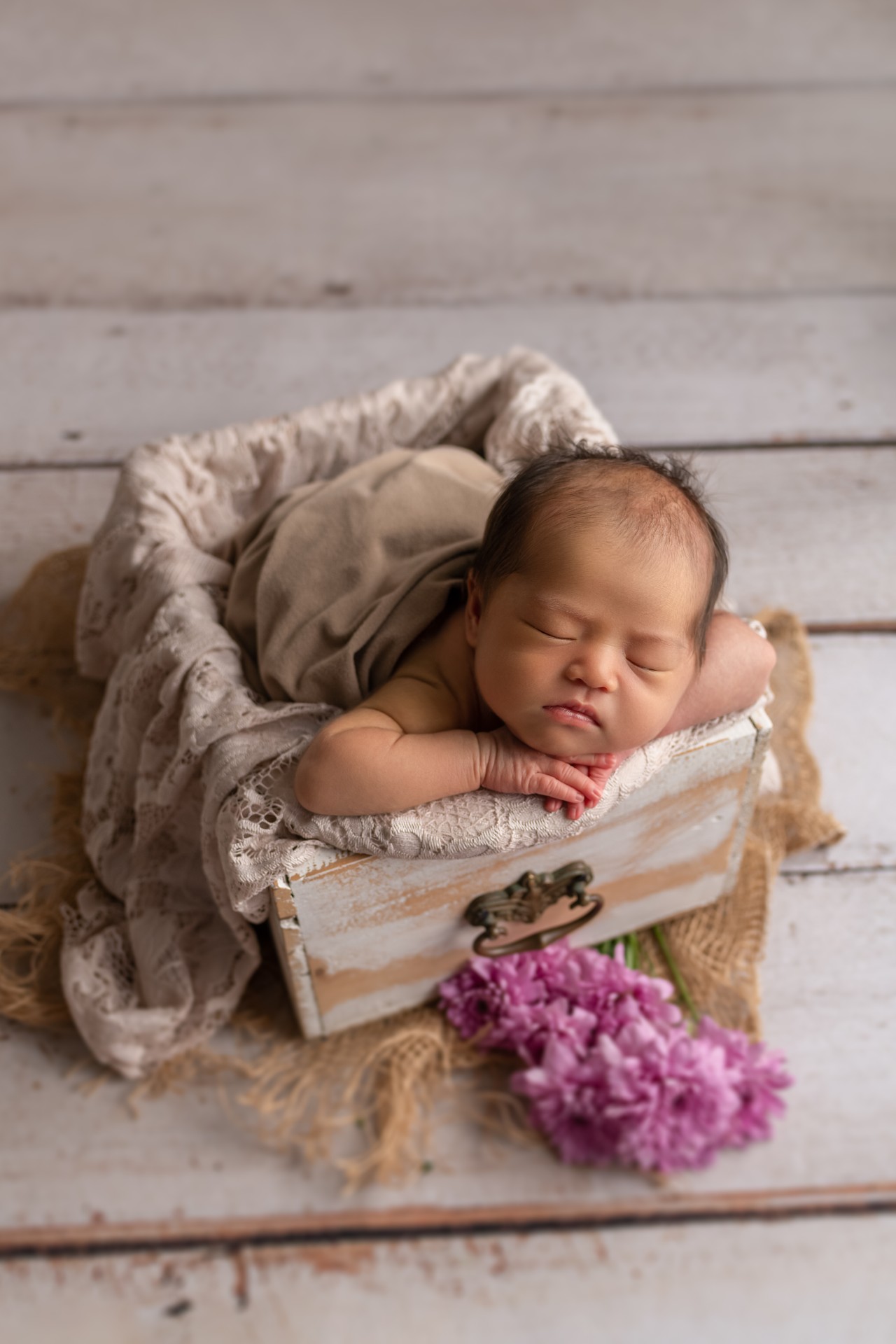 baby sleeping on the hands in the vintage drawer