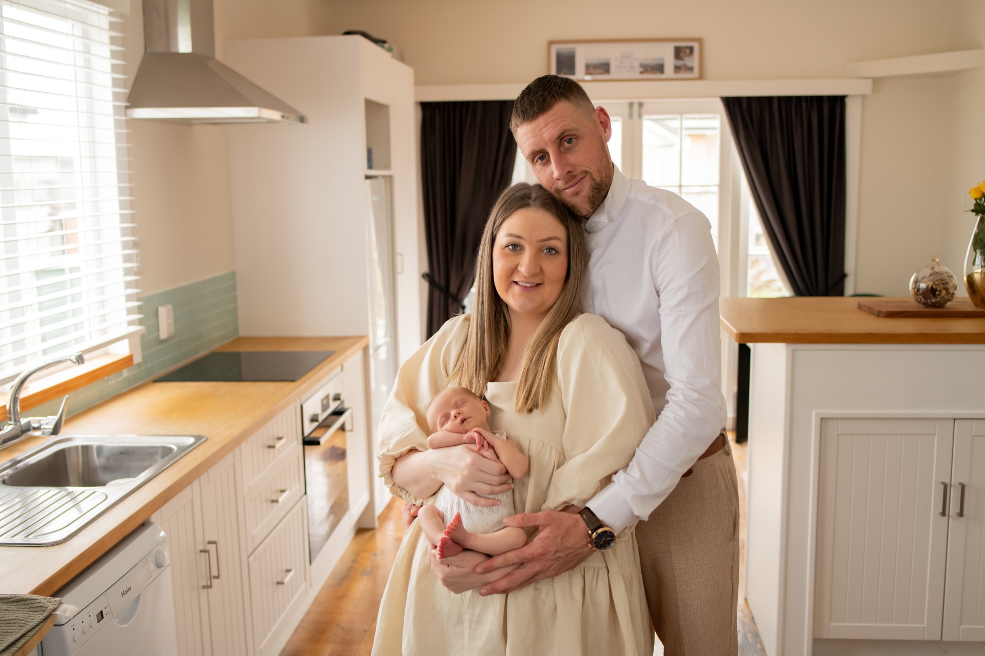 young family with the newborn in their kitchen