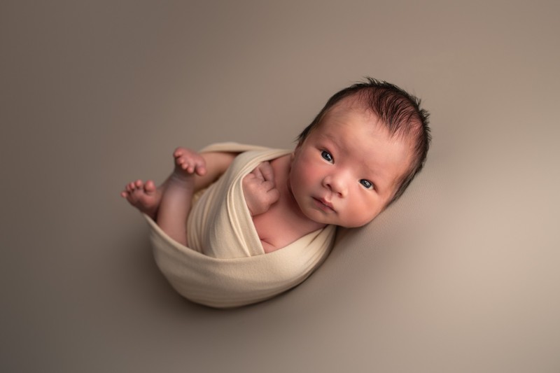 newborn baby wraped in beige wrap