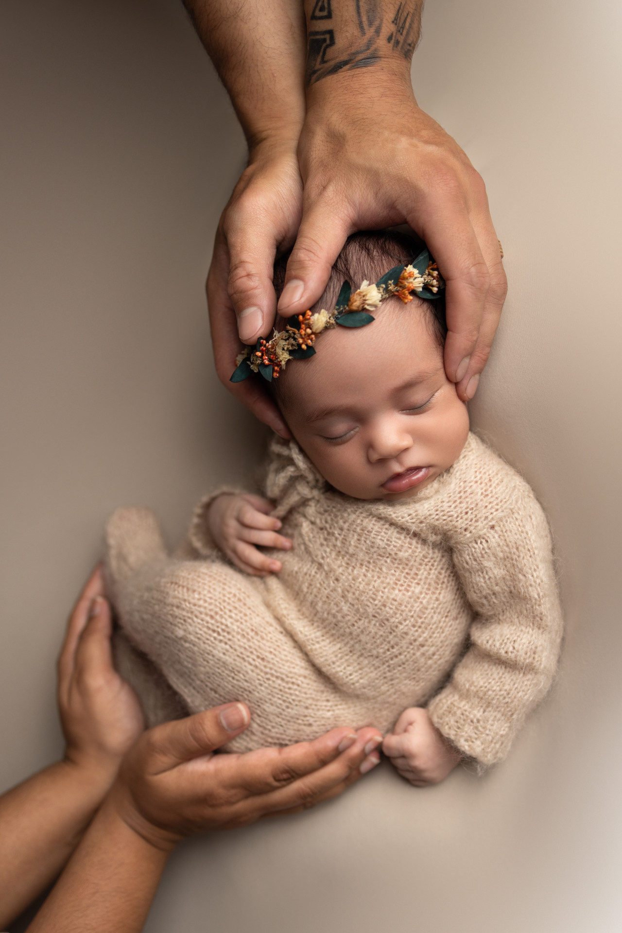 parents hands touching baby