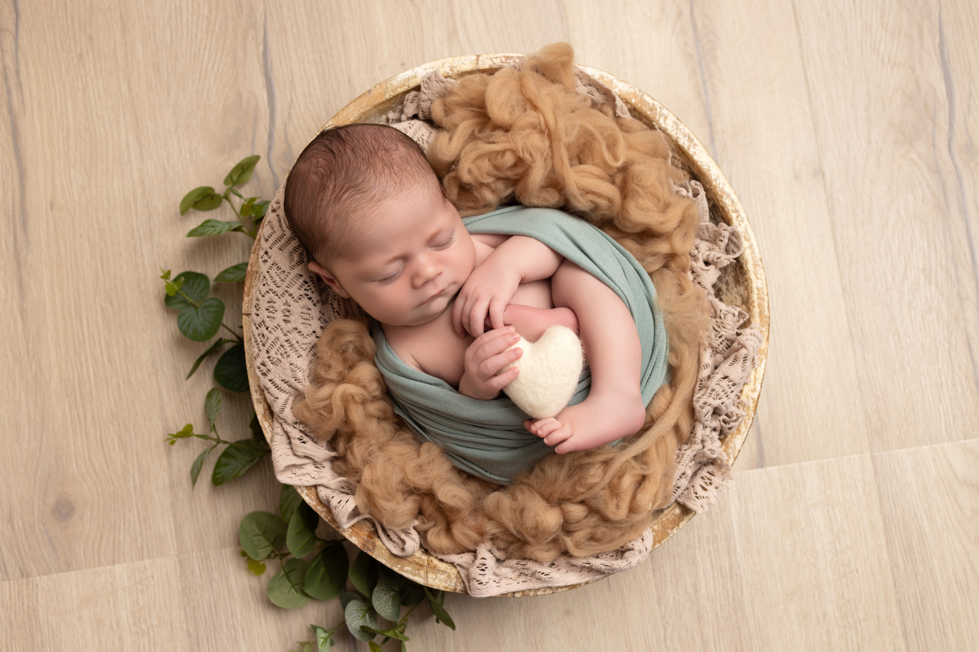 newborn in a circle bowl sleeping