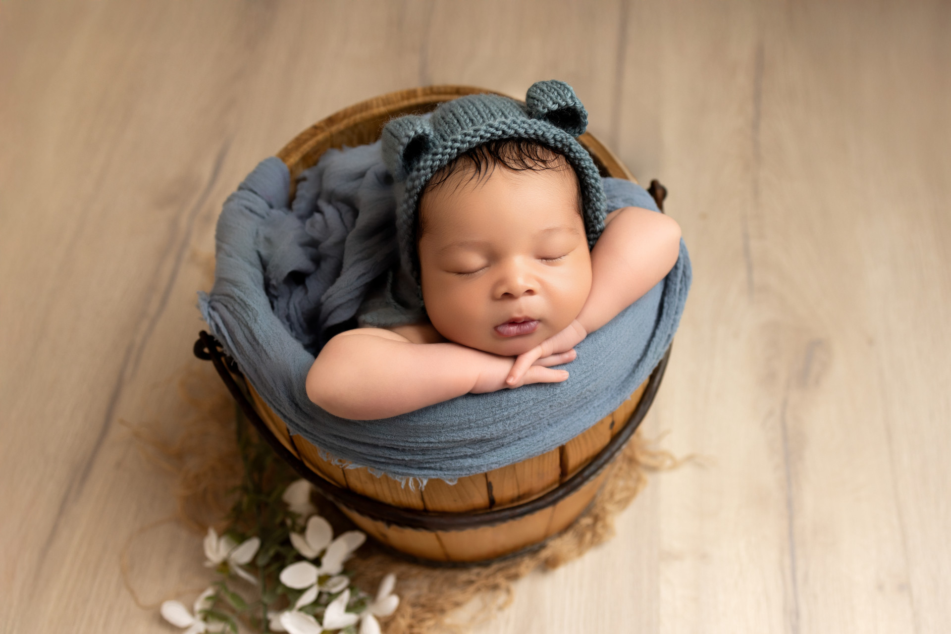 newborn with teddy bonnet in vintage wine bucket